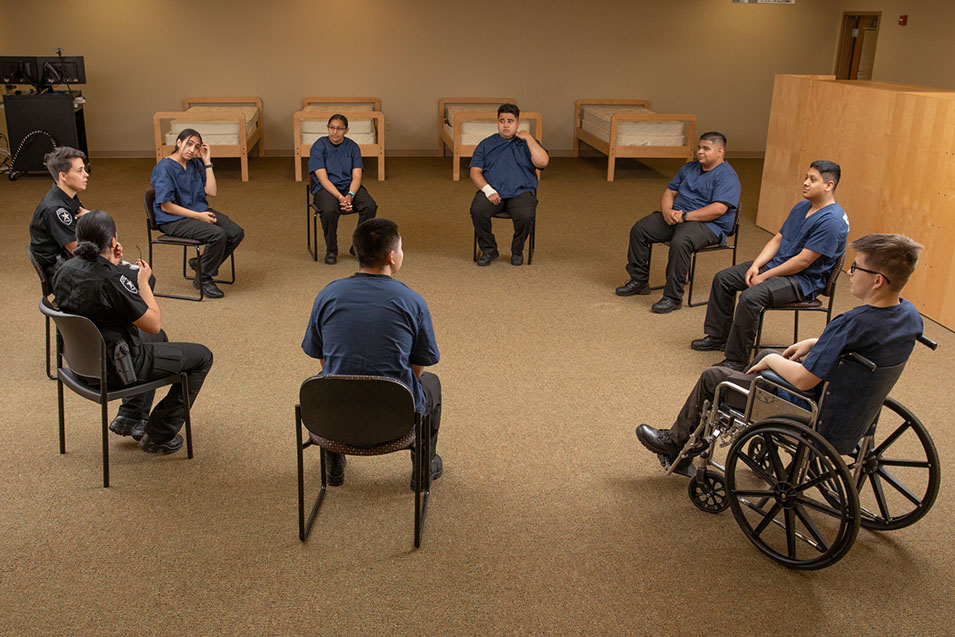 Juvenile Justice officers talking with a group of inmates